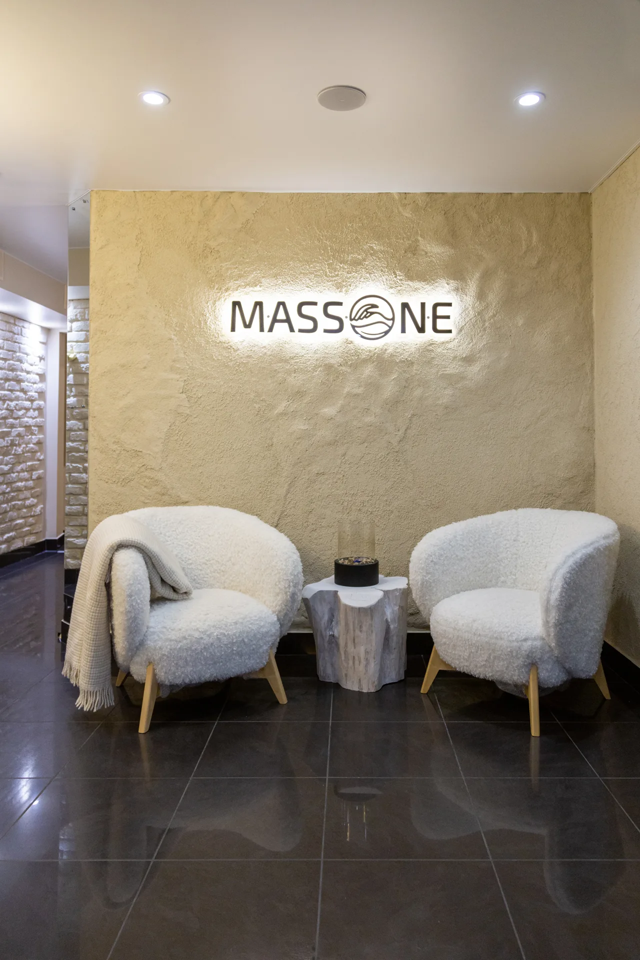 Холл с вывеской Massone и двумя белыми креслами